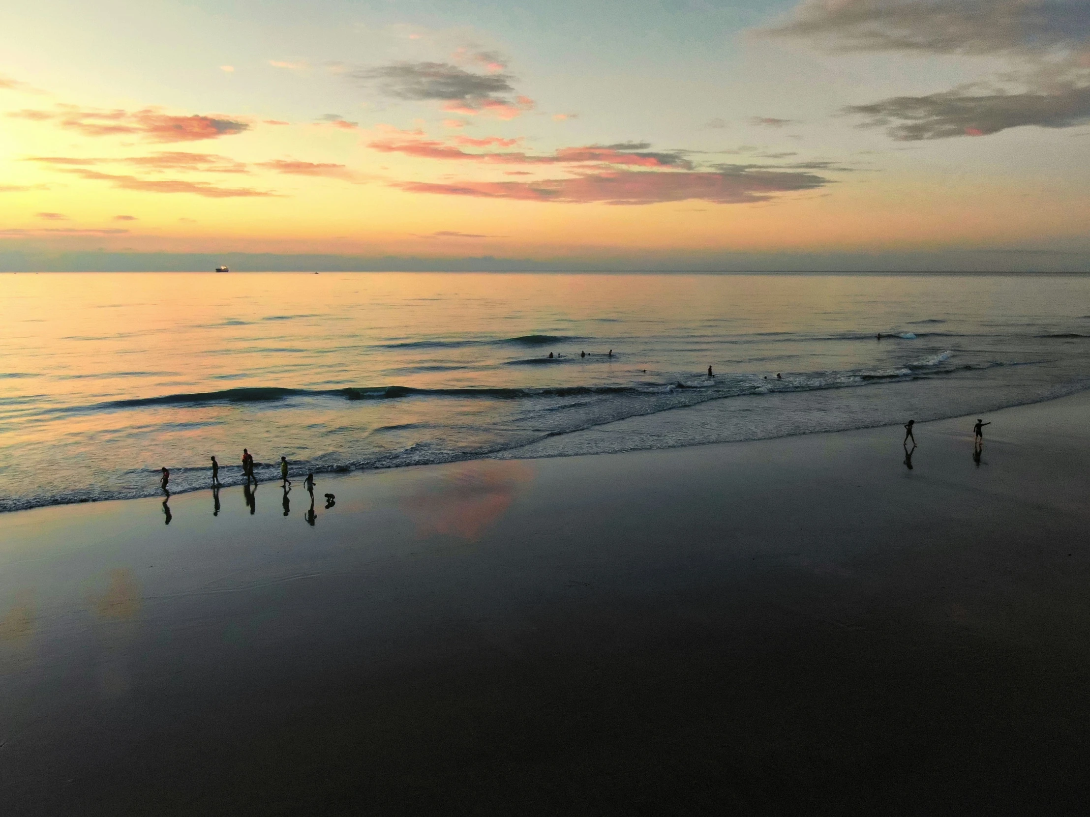 a group of people walking along a beach near the ocean