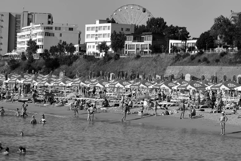 a bunch of beach goers on the beach in front of some els