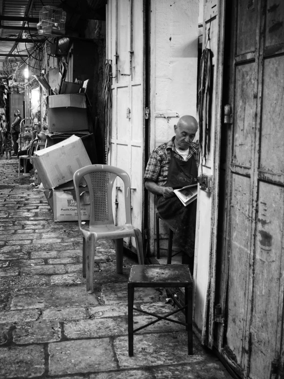 an older man sitting on a bench while looking at his cell phone