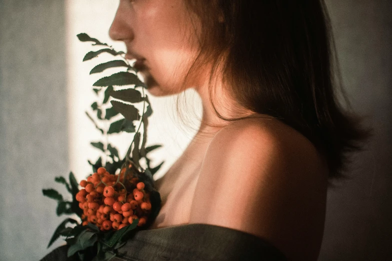 an attractive young lady with a plant in her hand