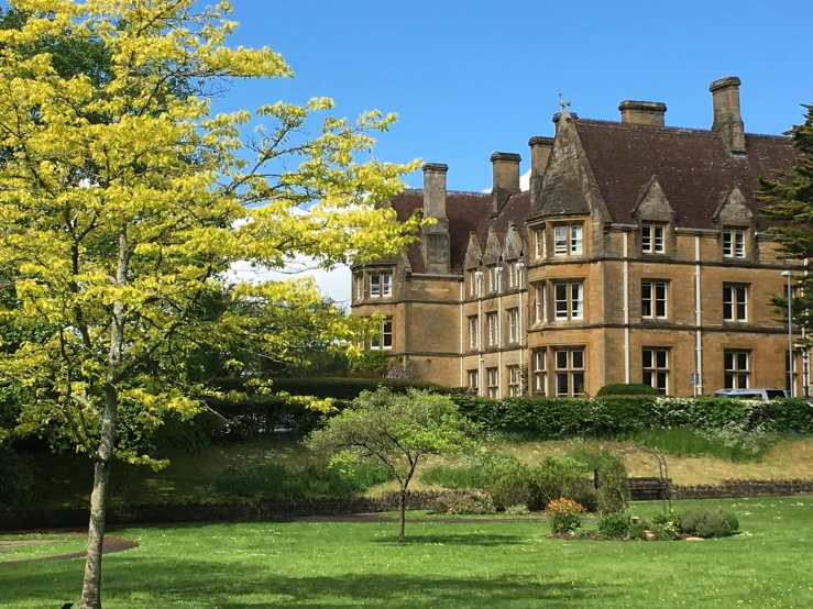 large brown castle with several windows and bushes around