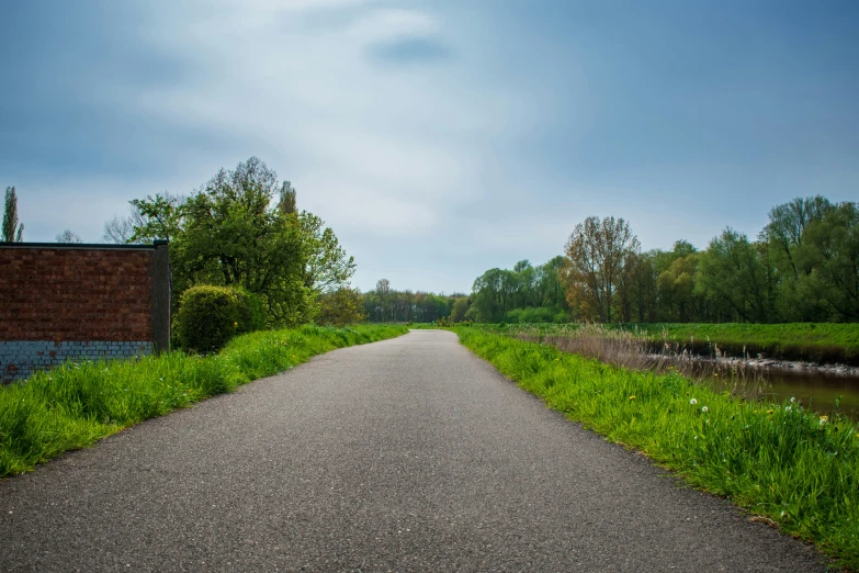 an empty road leading down to a lake