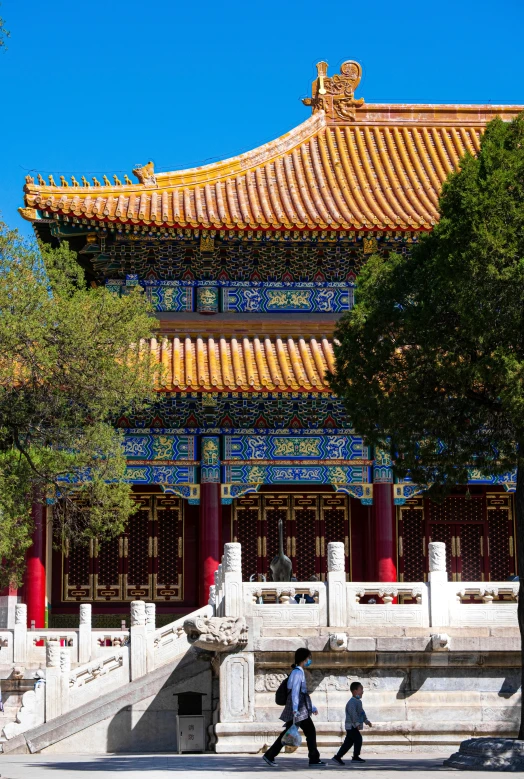 two people are walking near an oriental style building