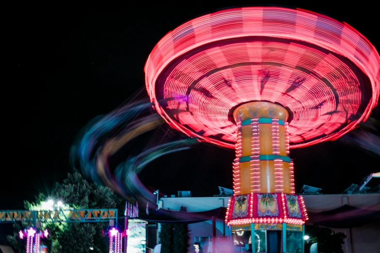 red spinning rides at night at a carnival