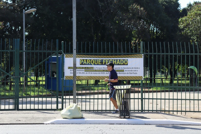 a man stands by a fence at the entrance to a playpen