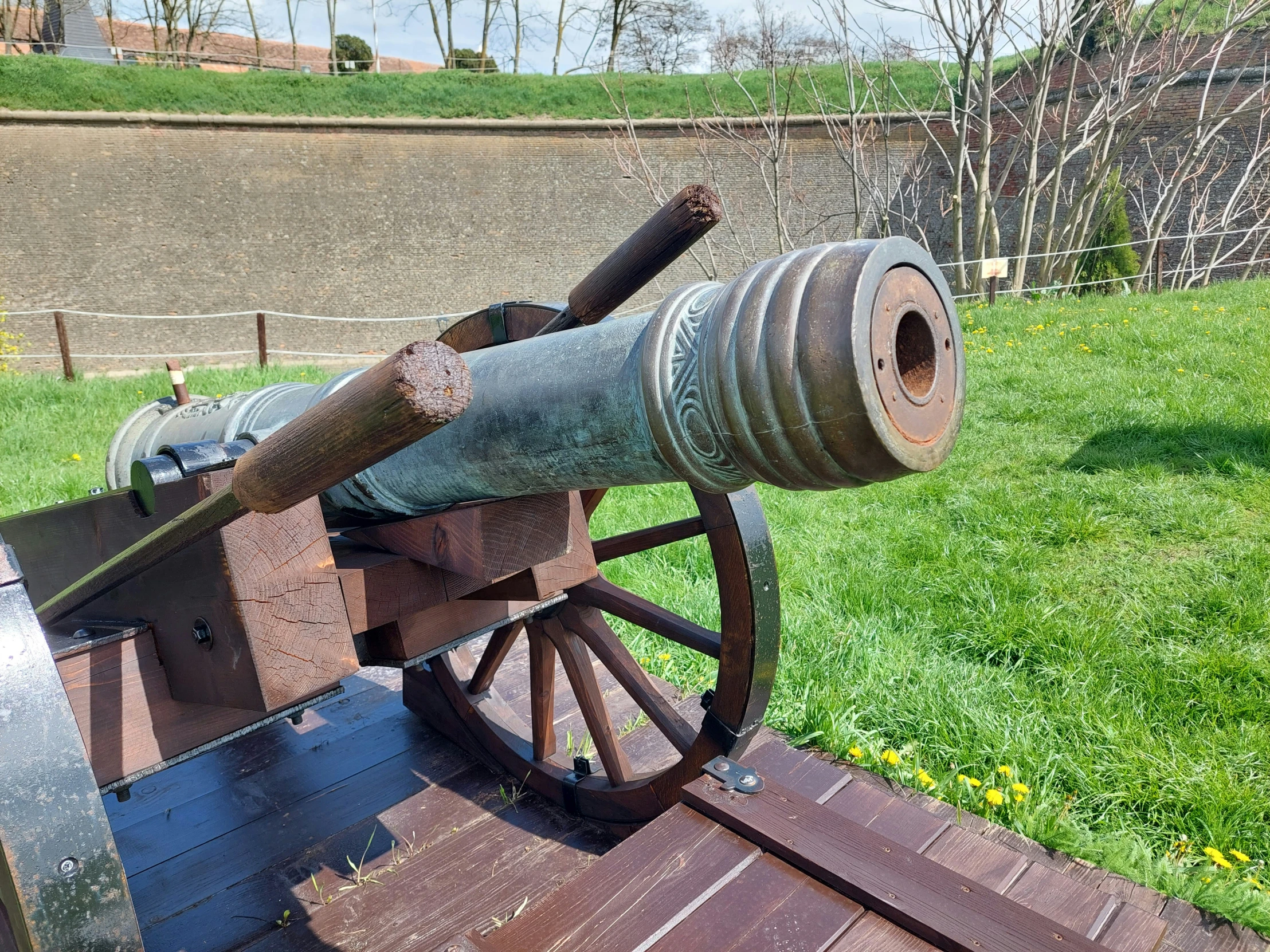 an old cannon resting on a bench in a grassy field