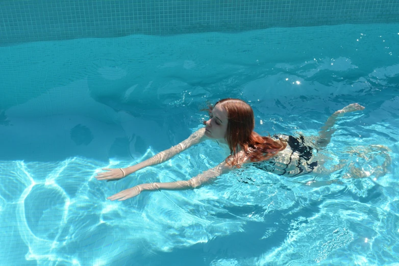 a woman floats in the water at the pool