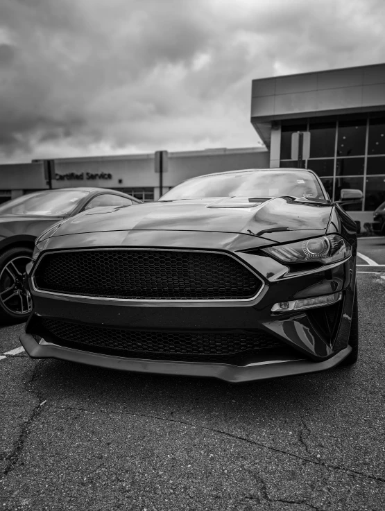a black ford mustang parked in front of a building