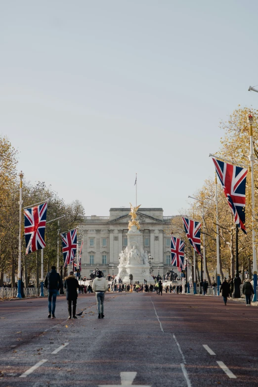 a city street has flags and trees with a building behind it