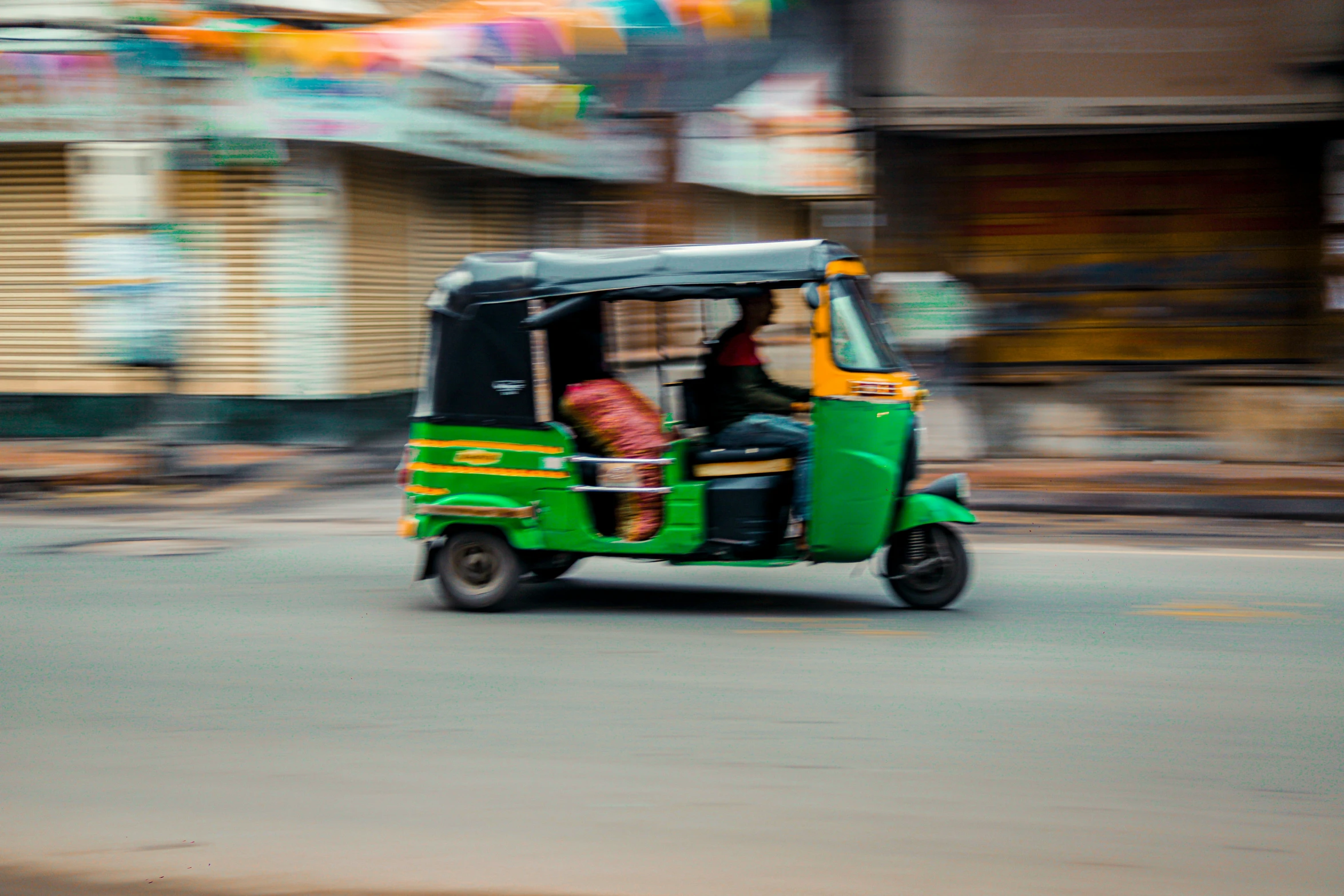 people in the back seat of a green and yellow passenger car