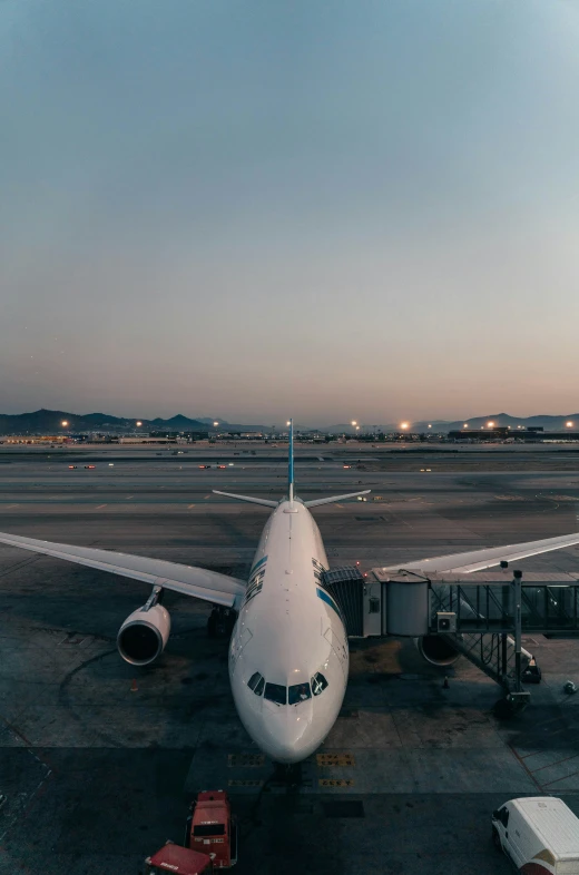 an airplane sitting on a runway at dusk