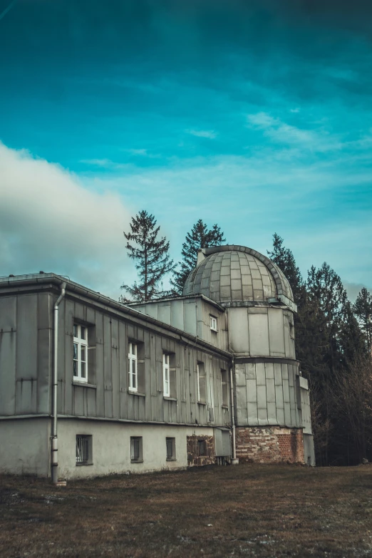 an old abandoned building has a round tower and an observation dome