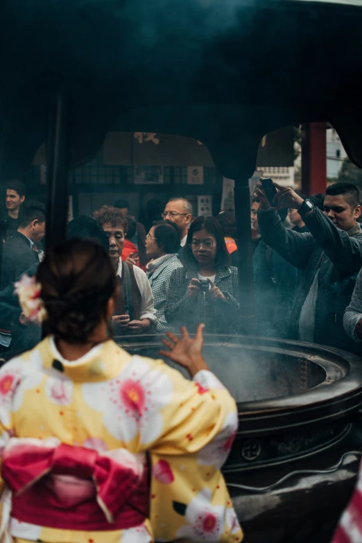 the women in kimonos are watching others play with sticks