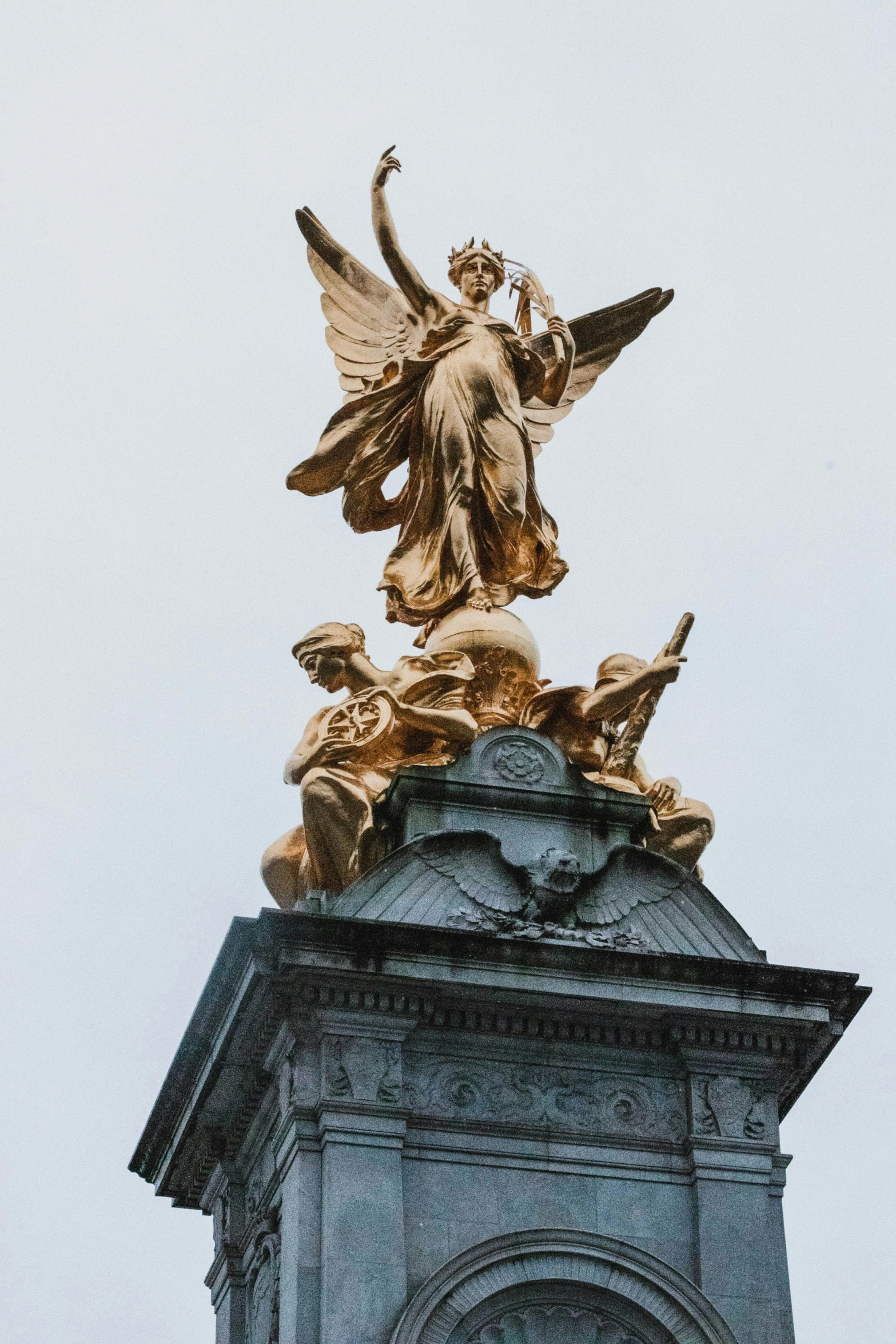an old statue atop a clock tower that shows an angel on top