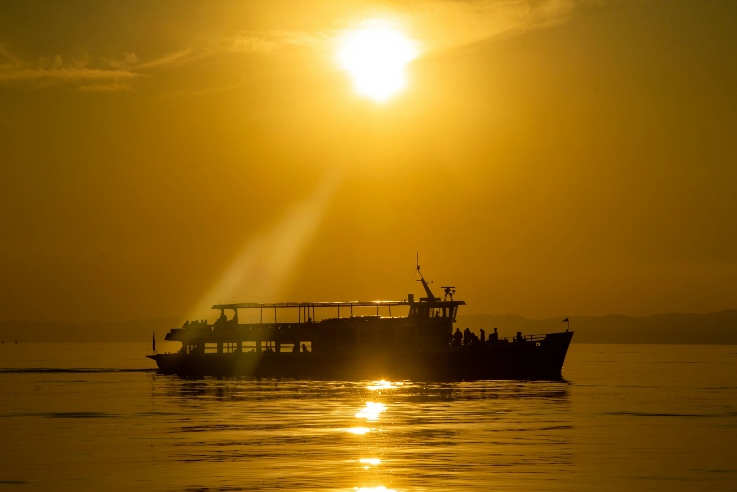 a boat on a body of water as the sun goes down