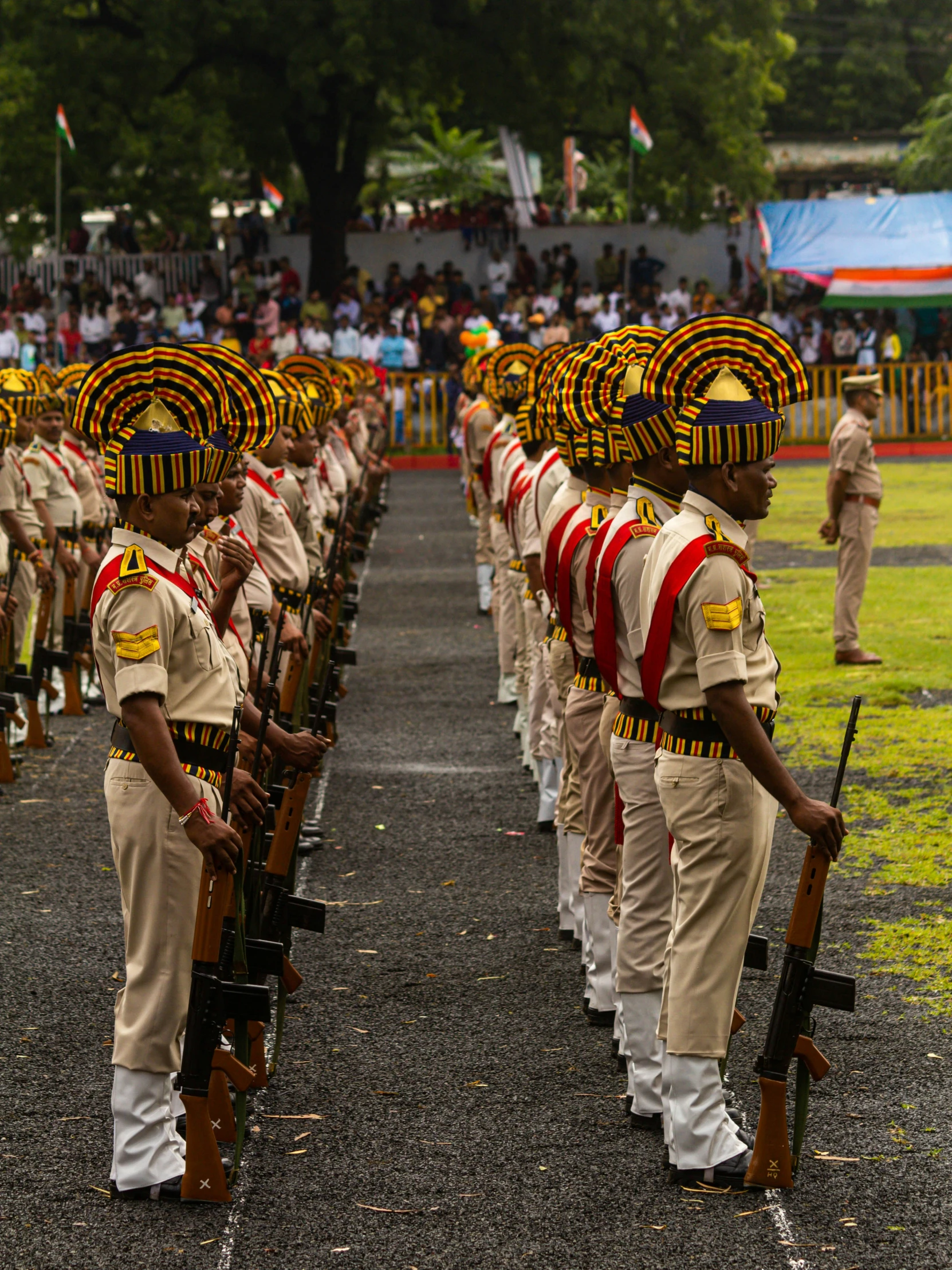 men dressed in uniforms stand with rifles and facing opposite directions