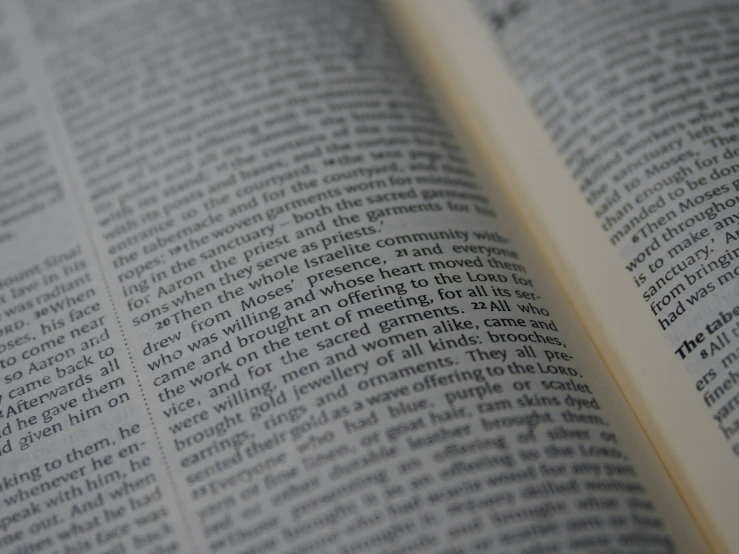 an open bible with a yellow key sitting on top of it