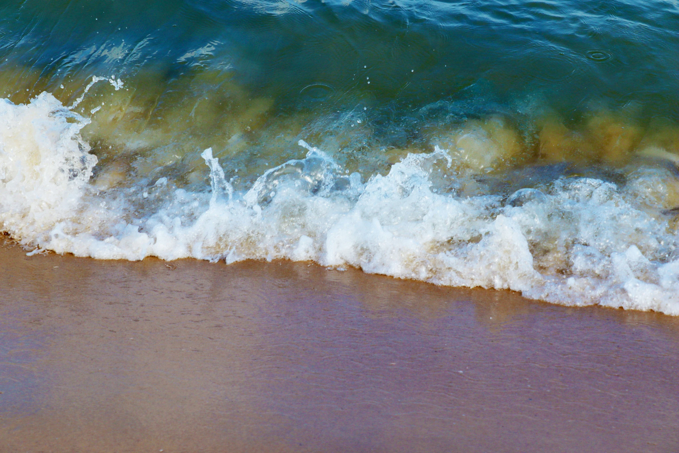 a very close up picture of a beach wave