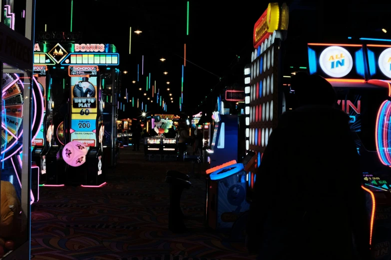 a woman walking down a street filled with neon signs