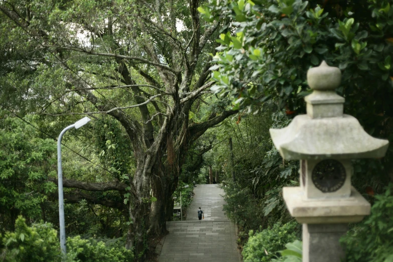 a stone pathway leads to a bench and an umbrella in the park