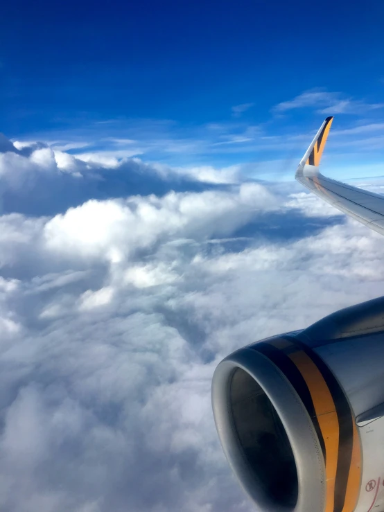 an airplane engine, viewed from the plane wing above the clouds