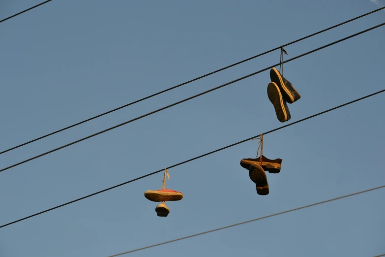 four pairs of shoes hanging from a line