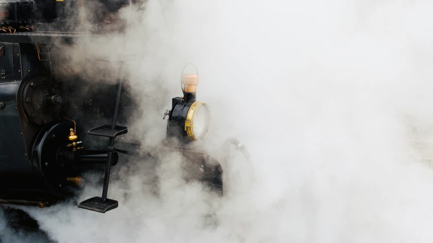 the smoke of a steam locomotive blows steam