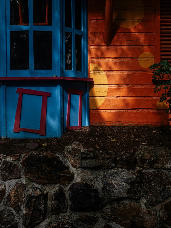 a po of a front door and a red and blue chair on the sidewalk