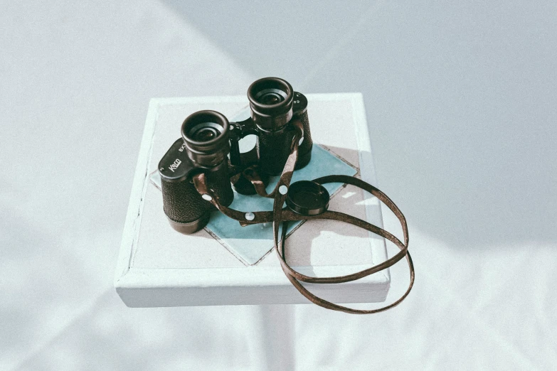 some old binoculars on a table with a strap