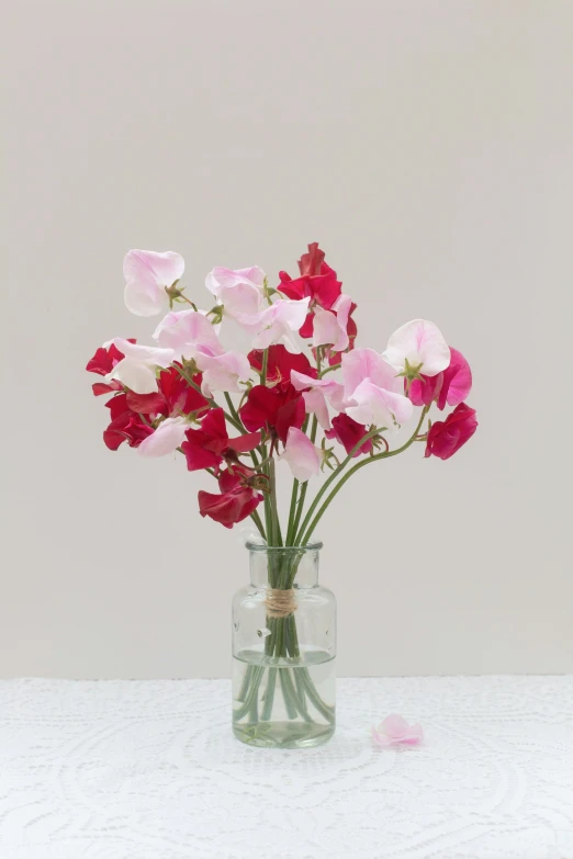 the vase is holding many pink and white flowers