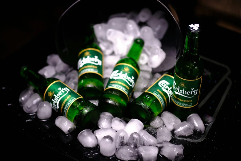 some bottles and ice on a black surface