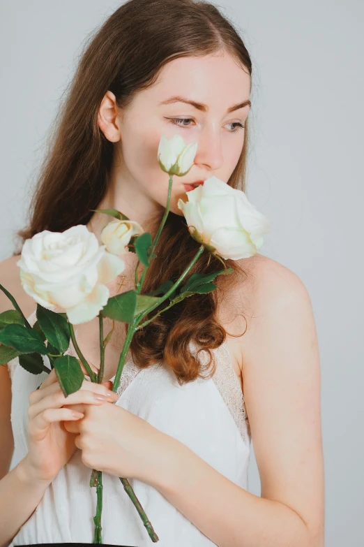 a woman is holding three roses in her hands