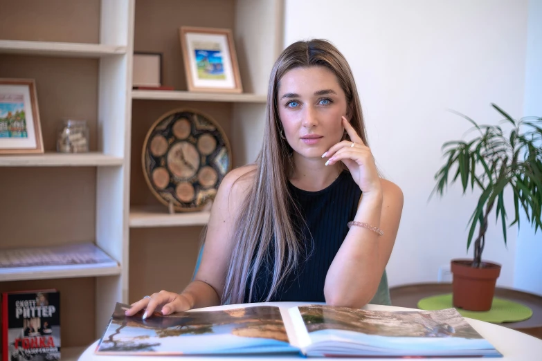 a woman sits at a table and talks on the phone