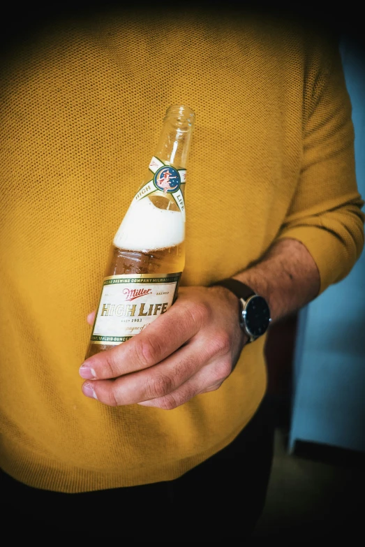 a man holding a small bottle of beer