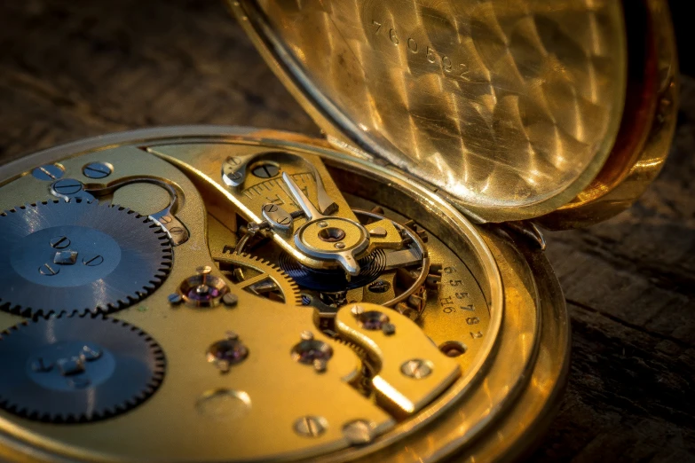 an opened pocket watch sitting on top of a wooden table