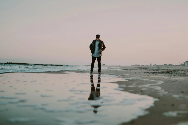 a person standing on the beach by the ocean