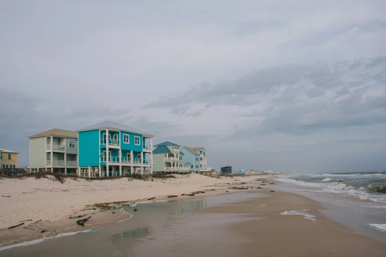many homes on the beach with waves in the background