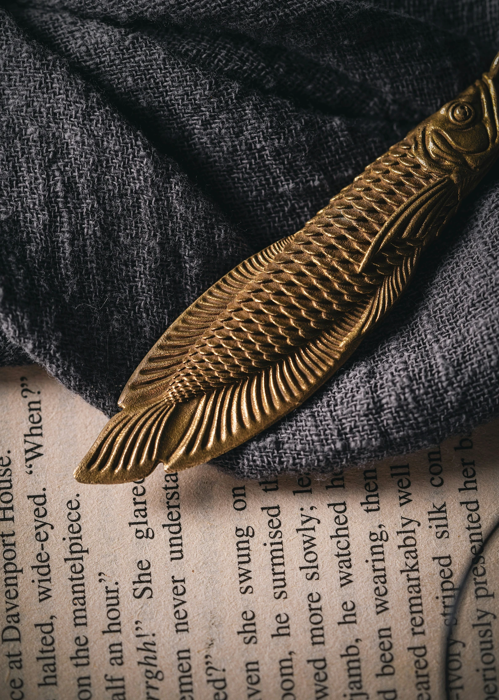 a golden metal brooch is resting on some denim