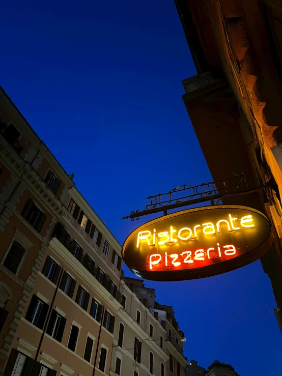 a neon sign that is hanging off the side of a building