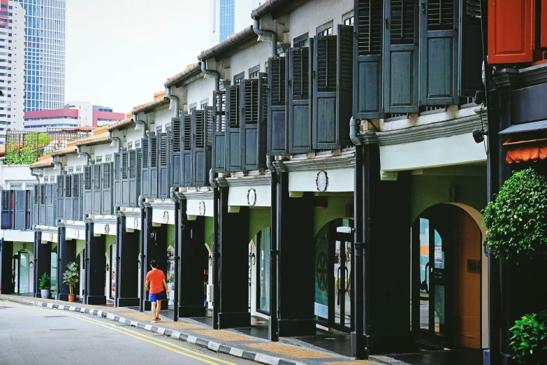 a man stands on the sidewalk outside of several buildings