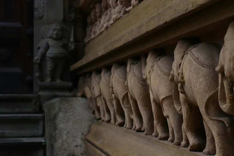 carved and carved elephants on an ornamental shelf