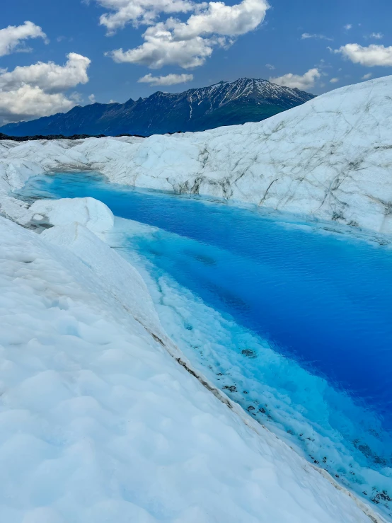 an expanse of snow with a blue river in the center