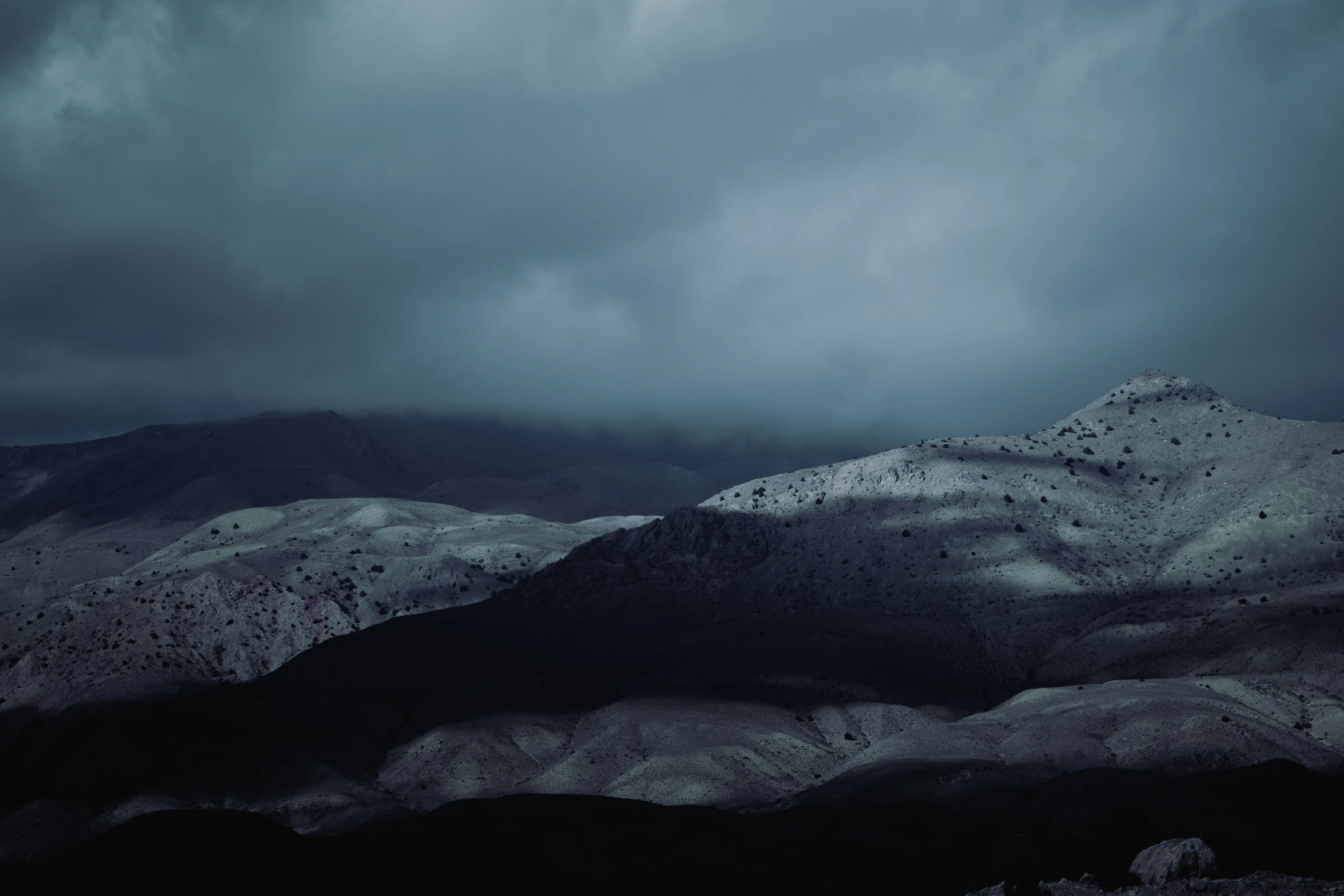 a snowy mountain under dark clouds and snow