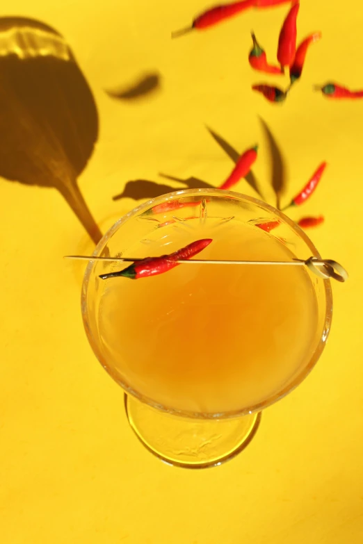 a glass of drinks with chili ketchup and a spoon