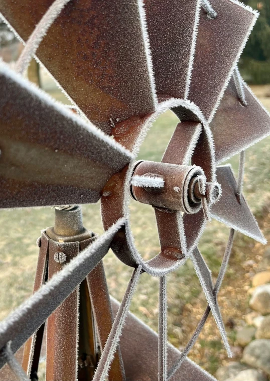 an old rusted metal propeller in a grassy area
