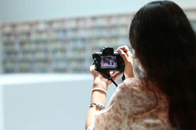 a woman holds a camera with one hand