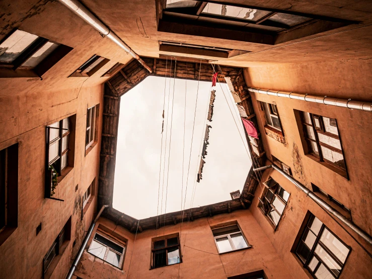 looking up at an apartment building's ceiling, which is below it is a balcony and with open doors