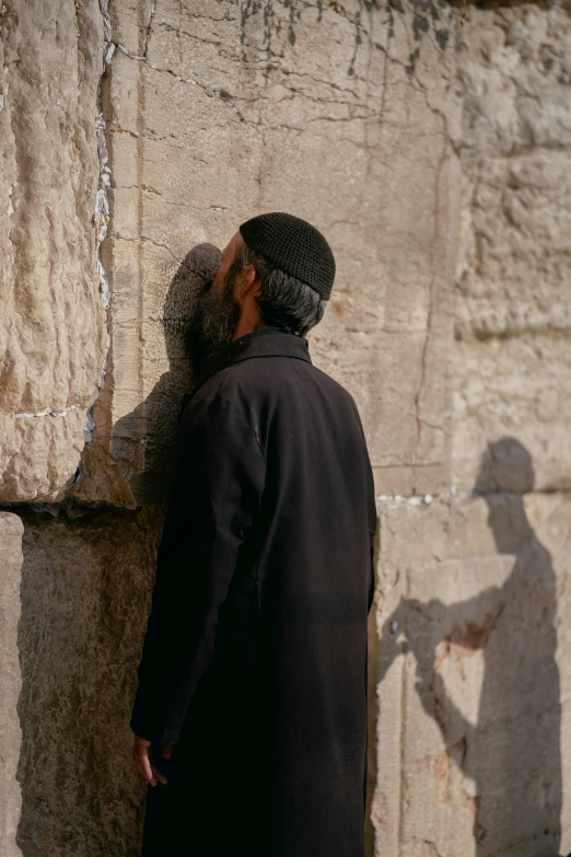 a person in silhouette next to the western desert stone wall