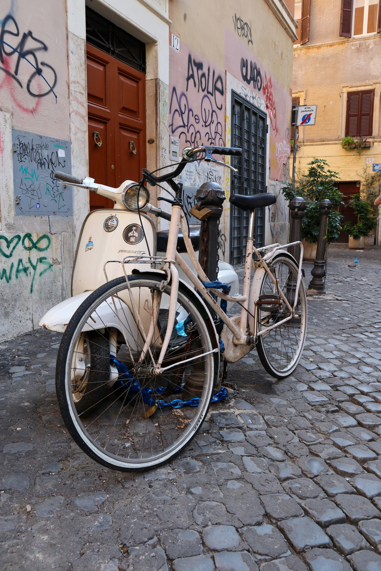 an old bike is parked in front of a wall with graffiti