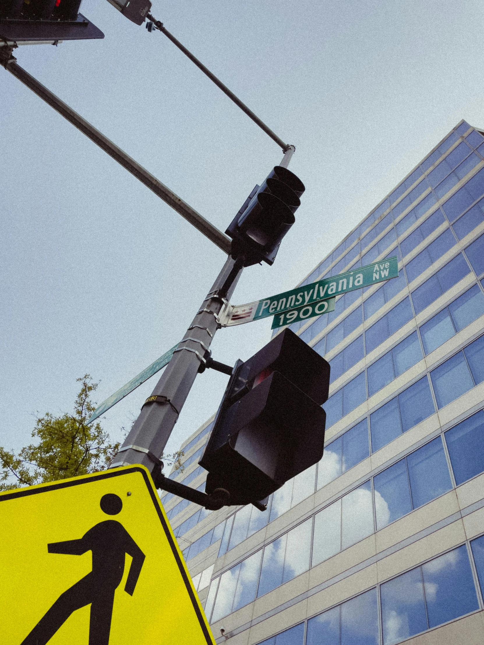 a pedestrian sign next to a stop light